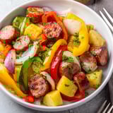 Skillet Bratwurst mit frisch geschnittenen Paprika und aromatischen Gewürzen genießen.  